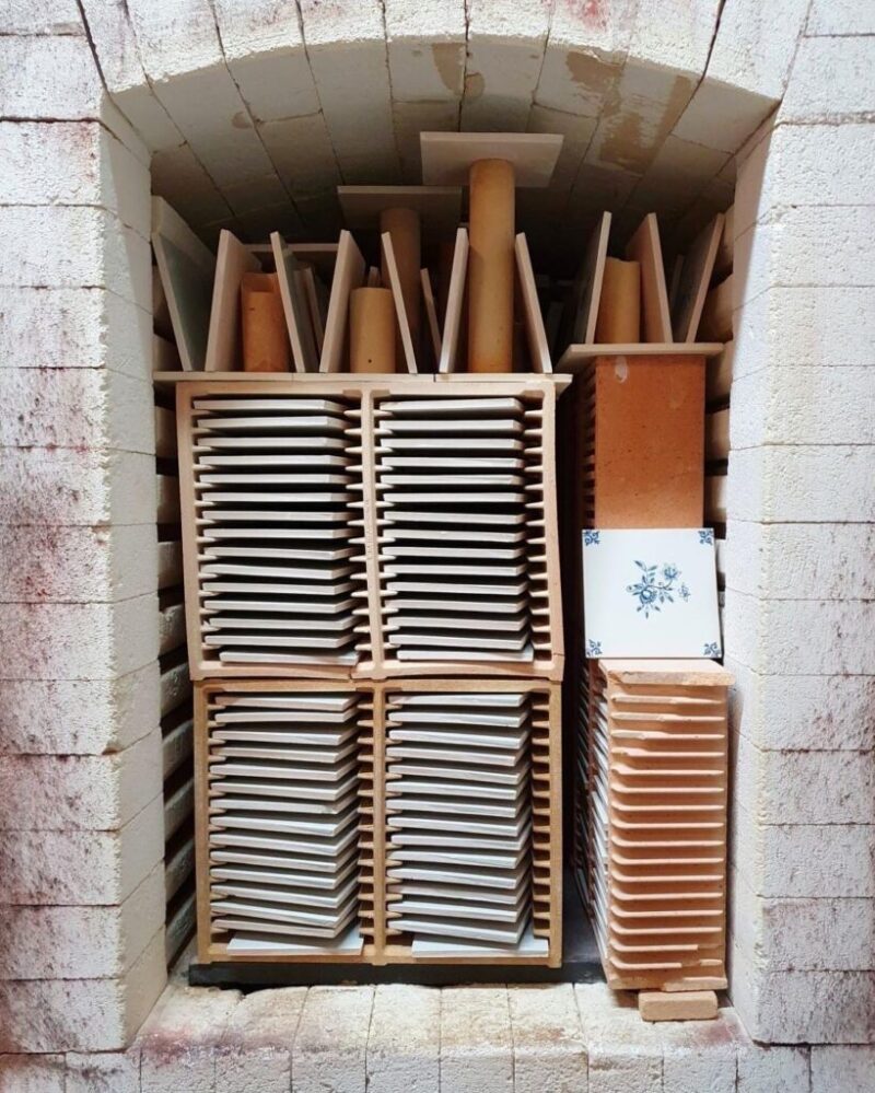 Stacked ceramic tiles laying on drying racks in kiln